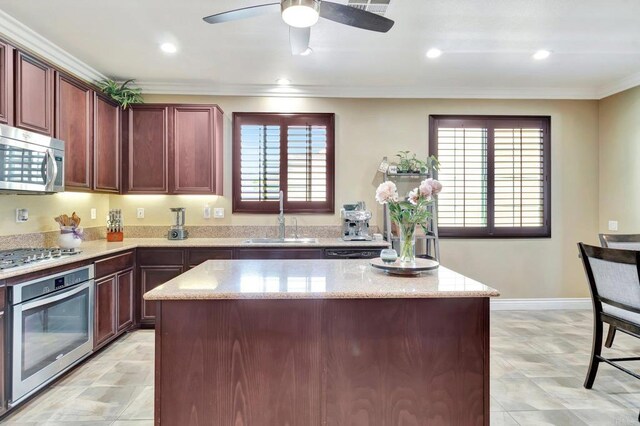 1349 Pyramid Peak St, Chula Vista, CA 91913 - kitchen featuring appliances with stainless steel finishes, healthy amount of natural light, a kitchen island, light stone counters, and ornamental molding