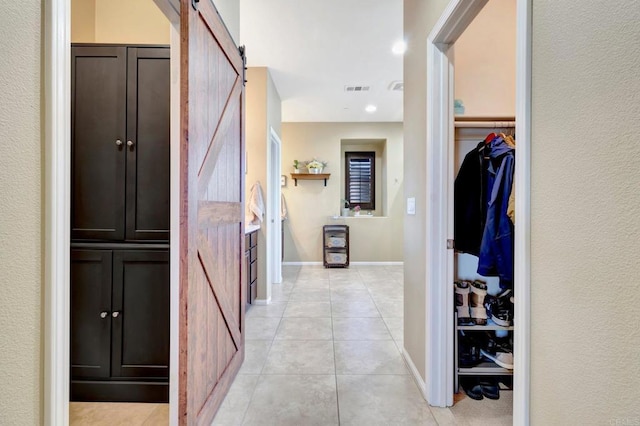 1349 Pyramid Peak St, Chula Vista, CA 91913 - hallway featuring light tile patterned flooring, a barn door, and recessed lighting