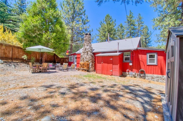 1815 Thrush Rd, Wrightwood, CA 92397 - rear view of property featuring a chimney, board and batten siding, a shed, and an outdoor hangout area