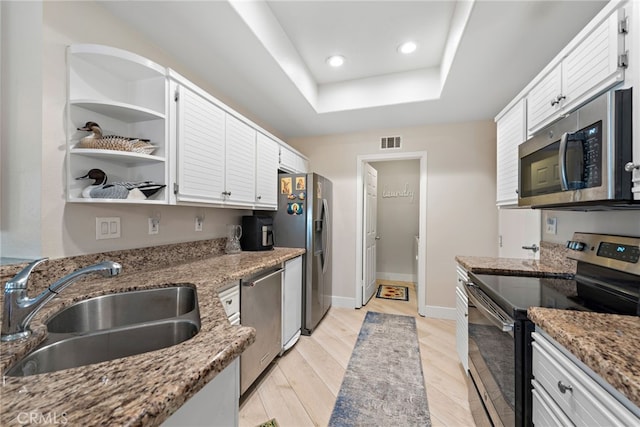 29 Baycrest Ct Unit 16, Newport Beach, CA 92660 - kitchen featuring appliances with stainless steel finishes, a tray ceiling, white cabinets, light stone countertops, and recessed lighting