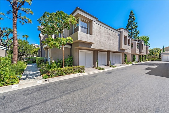 29 Baycrest Ct Unit 16, Newport Beach, CA 92660 - view of front facade with a garage and stucco siding