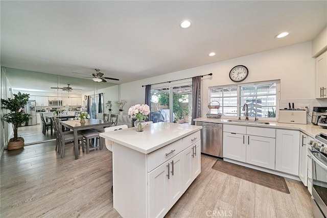 16011 Sugarpine Ln, Cerritos, CA 90703 - kitchen featuring stainless steel appliances, light countertops, ceiling fan, light wood-style flooring, and white cabinets