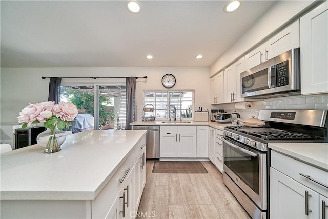 16011 Sugarpine Ln, Cerritos, CA 90703 - kitchen featuring stainless steel appliances, light countertops, recessed lighting, white cabinetry, and light wood-style flooring