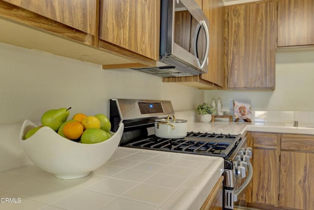 644 Orwell Ln, Ventura, CA 93003 - kitchen with appliances with stainless steel finishes, tile counters, and brown cabinetry