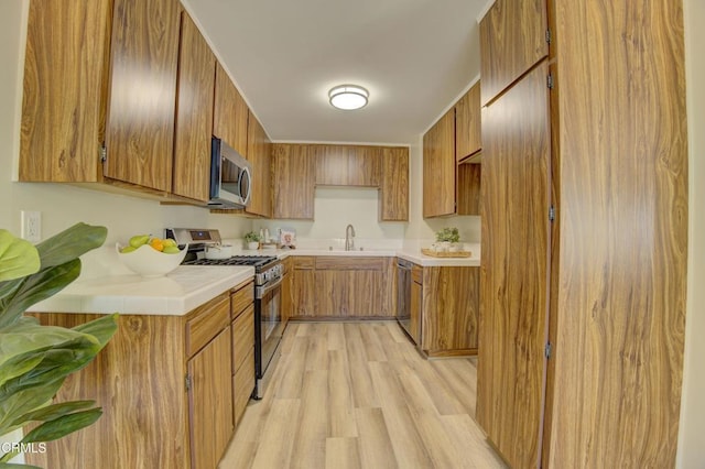 644 Orwell Ln, Ventura, CA 93003 - kitchen featuring stainless steel appliances, brown cabinets, light wood finished floors, and light countertops
