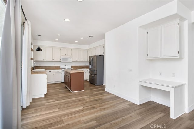31257 Casera Ct, Menifee, CA 92584 - kitchen featuring white appliances, light wood finished floors, light countertops, recessed lighting, and white cabinets