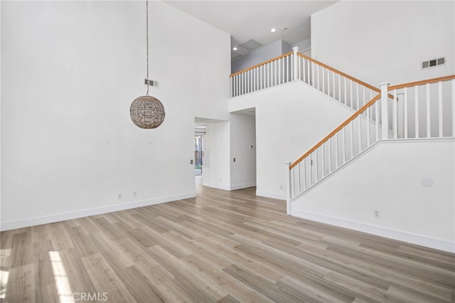 31257 Casera Ct, Menifee, CA 92584 - unfurnished living room featuring wood finished floors, stairway, and a towering ceiling