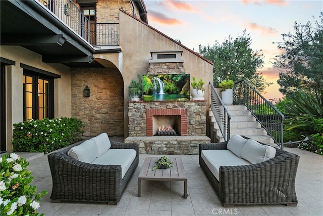 4 Thomas Rd, Ladera Ranch, CA 92694 - patio terrace at dusk with an outdoor living space with a fireplace, a patio, and stairway