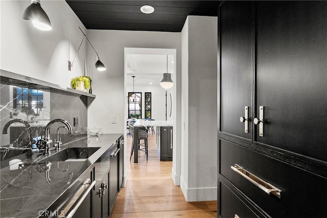 4 Thomas Rd, Ladera Ranch, CA 92694 - kitchen featuring open shelves, dark cabinetry, tasteful backsplash, and light wood-style floors