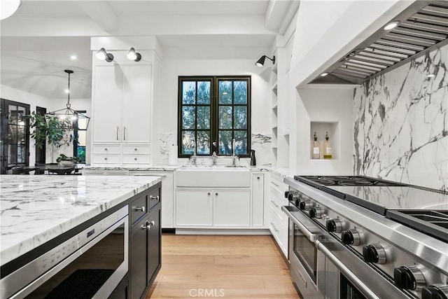 4 Thomas Rd, Ladera Ranch, CA 92694 - kitchen with stainless steel appliances, ventilation hood, light stone counters, backsplash, and white cabinets