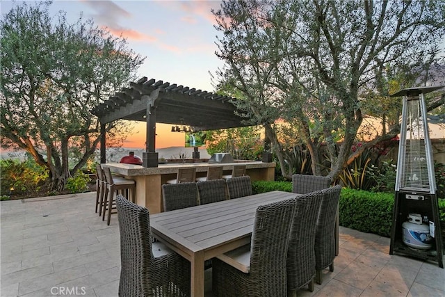 4 Thomas Rd, Ladera Ranch, CA 92694 - patio terrace at dusk featuring a pergola, a patio, and an outdoor kitchen