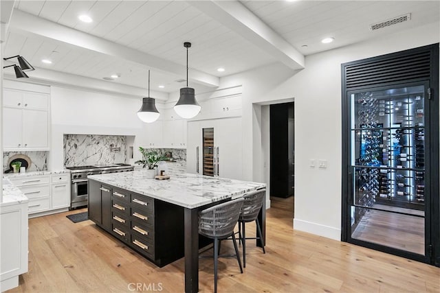 4 Thomas Rd, Ladera Ranch, CA 92694 - kitchen featuring dark cabinets, white cabinets, stainless steel range, backsplash, and light wood-style flooring