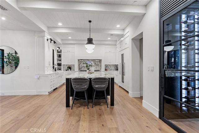 4 Thomas Rd, Ladera Ranch, CA 92694 - kitchen with beamed ceiling, light wood finished floors, white cabinets, a center island, and a kitchen breakfast bar