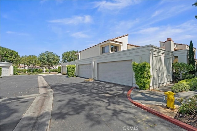 29 Morena Unit 35, Irvine, CA 92612 - view of side of home with stucco siding and community garages