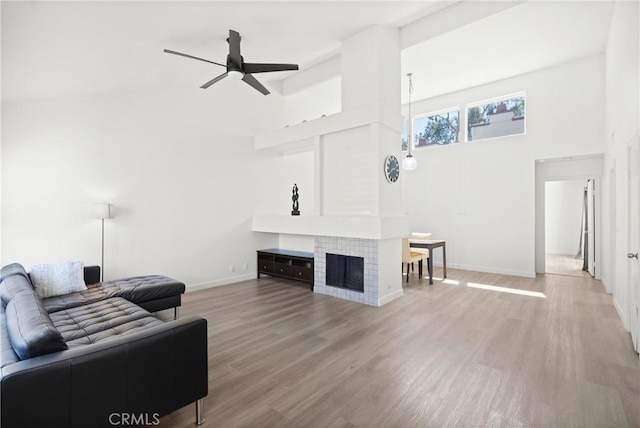 29 Morena Unit 35, Irvine, CA 92612 - living area featuring a ceiling fan, light wood-style floors, a high ceiling, and a tile fireplace