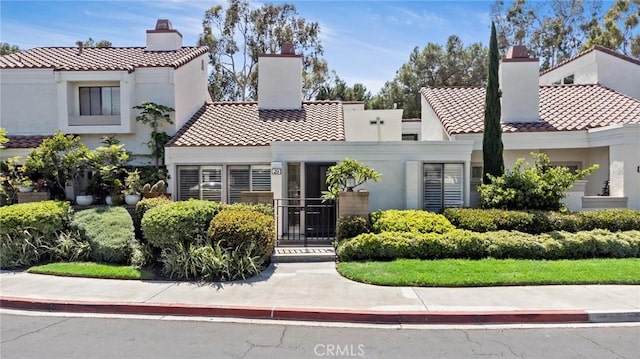 29 Morena Unit 35, Irvine, CA 92612 - mediterranean / spanish-style home with a chimney, a tile roof, and stucco siding
