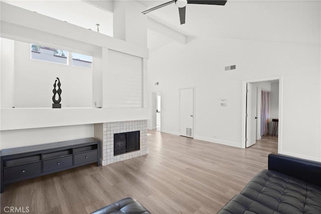 29 Morena Unit 35, Irvine, CA 92612 - unfurnished living room featuring ceiling fan, high vaulted ceiling, wood finished floors, a tiled fireplace, and beam ceiling