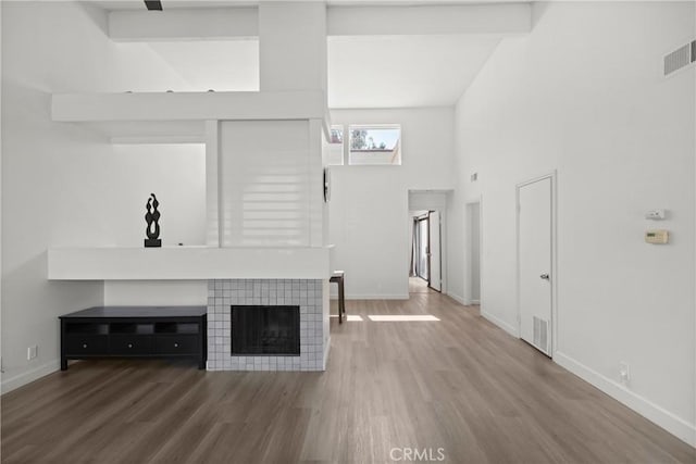 29 Morena Unit 35, Irvine, CA 92612 - unfurnished living room featuring wood finished floors, a fireplace, and high vaulted ceiling