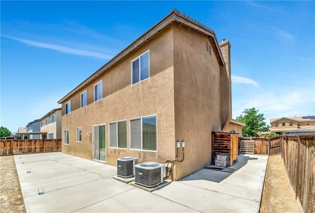 2354 Crimson Ave, Rosamond, CA 93560 - rear view of house featuring a patio, stucco siding, a fenced backyard, and a chimney