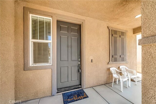 2354 Crimson Ave, Rosamond, CA 93560 - doorway to property featuring stucco siding and covered porch