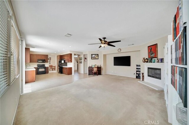 2354 Crimson Ave, Rosamond, CA 93560 - unfurnished living room with a glass covered fireplace, light carpet, ceiling fan, and recessed lighting