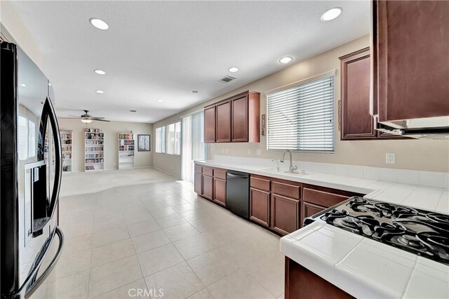 2354 Crimson Ave, Rosamond, CA 93560 - kitchen with refrigerator with ice dispenser, dishwashing machine, tile countertops, range with gas stovetop, and ceiling fan