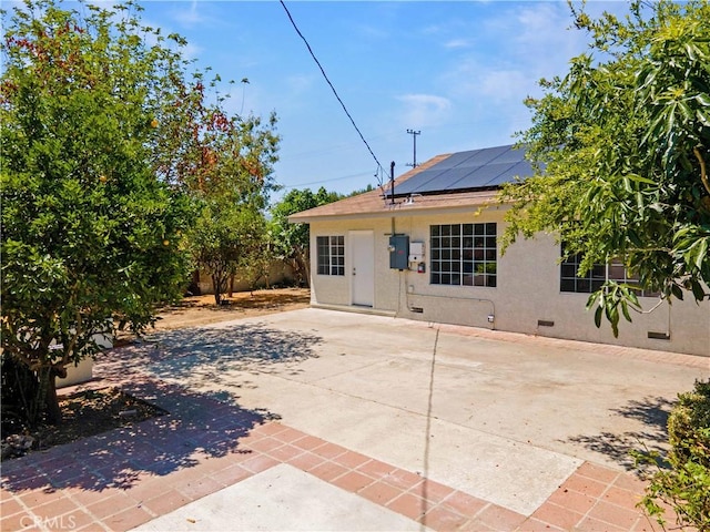 20328 Roscoe Blvd, Winnetka, CA 91306 - rear view of property featuring stucco siding, roof mounted solar panels, and a patio