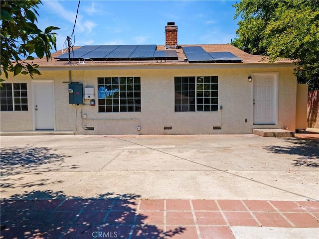 20328 Roscoe Blvd, Winnetka, CA 91306 - back of property featuring crawl space, stucco siding, a chimney, and roof mounted solar panels