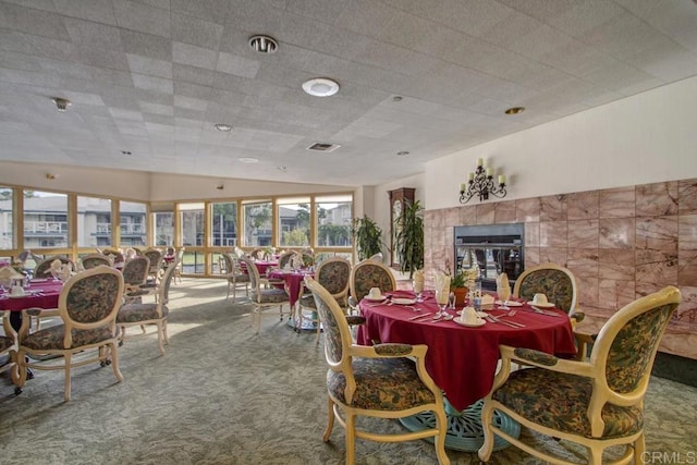 1682 Circa Del Lago Unit A306, San Marcos, CA 92078 - dining area featuring carpet flooring, a tiled fireplace, and lofted ceiling
