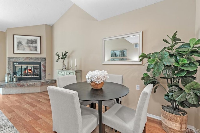 1682 Circa Del Lago Unit A306, San Marcos, CA 92078 - dining space with wood finished floors, lofted ceiling, and a high end fireplace