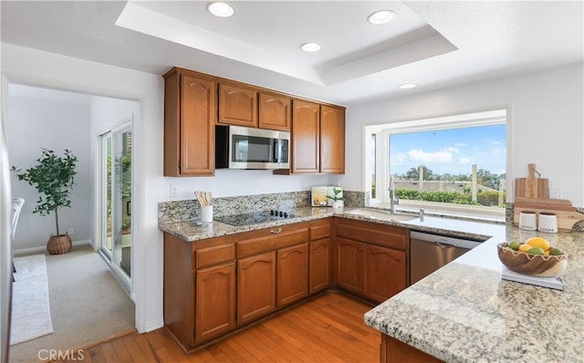 2245 Avenida Oliva, San Clemente, CA 92673 - kitchen with appliances with stainless steel finishes, a raised ceiling, light wood-style flooring, brown cabinetry, and recessed lighting