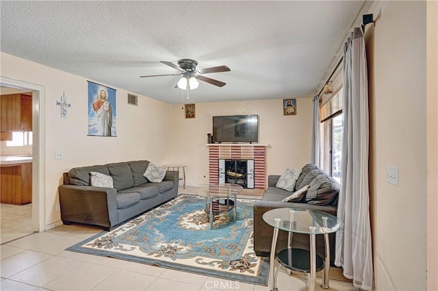 260 E Whittier Ave, Hemet, CA 92543 - tiled living room with a ceiling fan, a fireplace, and a textured ceiling