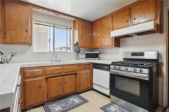 260 E Whittier Ave, Hemet, CA 92543 - kitchen with appliances with stainless steel finishes, under cabinet range hood, brown cabinets, and backsplash