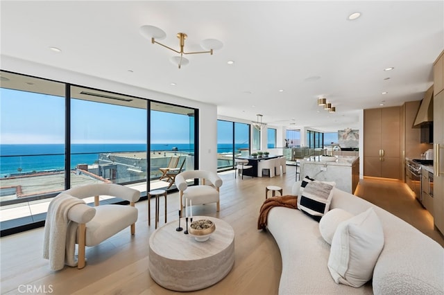 316 32nd St, Manhattan Beach, CA 90266 - living room featuring expansive windows, light wood-style flooring, a water view, and recessed lighting