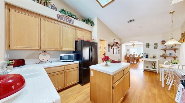 7075 Montana Ave, Fontana, CA 92336 - kitchen with freestanding refrigerator, tile counters, stainless steel microwave, a center island, and light wood finished floors