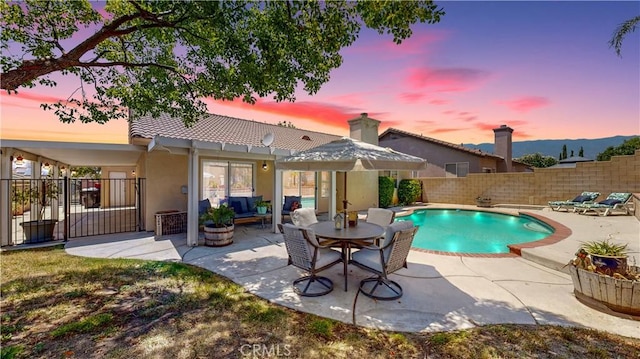 7075 Montana Ave, Fontana, CA 92336 - pool at dusk featuring a fenced backyard, a patio area, outdoor lounge area, and a pergola
