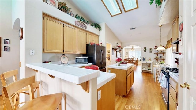 7075 Montana Ave, Fontana, CA 92336 - kitchen with stainless steel microwave, gas range oven, freestanding refrigerator, a kitchen island, and a peninsula