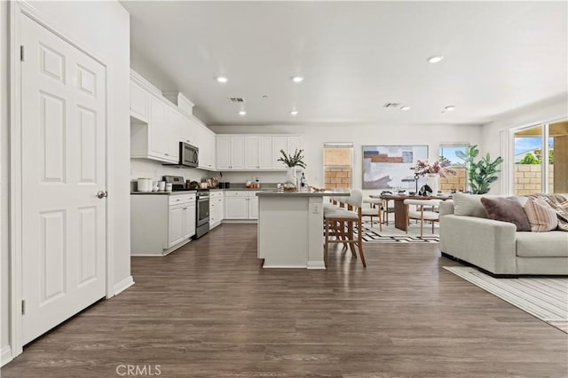 4733 S Rogers Way, Ontario, CA 91762 - kitchen with stainless steel appliances, open floor plan, white cabinets, recessed lighting, and a kitchen breakfast bar
