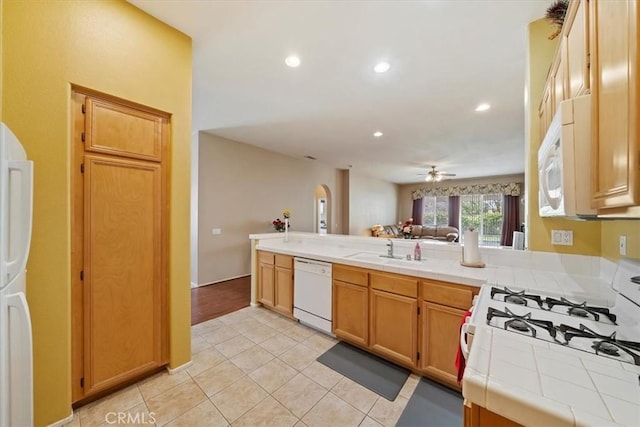 12744 Palmetto Ct, Riverside, CA 92503 - kitchen with white appliances, tile counters, a ceiling fan, light tile patterned floors, and a peninsula