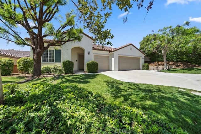 12744 Palmetto Ct, Riverside, CA 92503 - mediterranean / spanish-style home featuring a garage, stucco siding, concrete driveway, a front lawn, and a tile roof