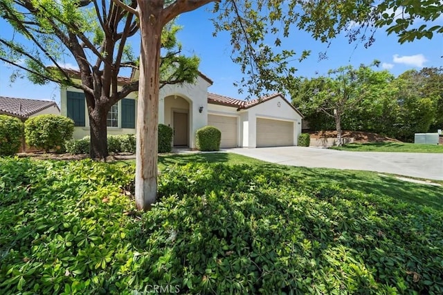 12744 Palmetto Ct, Riverside, CA 92503 - mediterranean / spanish-style home with an attached garage, driveway, stucco siding, a front yard, and a tile roof