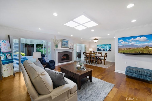 5185 Duenas, Laguna Woods, CA 92637 - living area with crown molding, wood finished floors, a warm lit fireplace, and recessed lighting