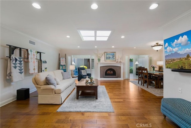5185 Duenas, Laguna Woods, CA 92637 - living area featuring ornamental molding, wood finished floors, a fireplace with raised hearth, and recessed lighting
