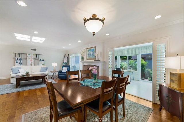 5185 Duenas, Laguna Woods, CA 92637 - dining area with ornamental molding, wood finished floors, recessed lighting, and a fireplace