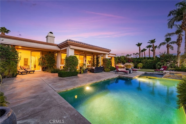 56102 Baltusrol Ln, Quinta, CA 92253 - pool at dusk featuring a patio, an outdoor hangout area, and a pool with connected hot tub