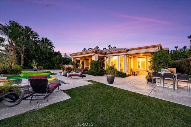 56102 Baltusrol Ln, Quinta, CA 92253 - back of house featuring a lawn, a patio, an outdoor pool, and a tile roof