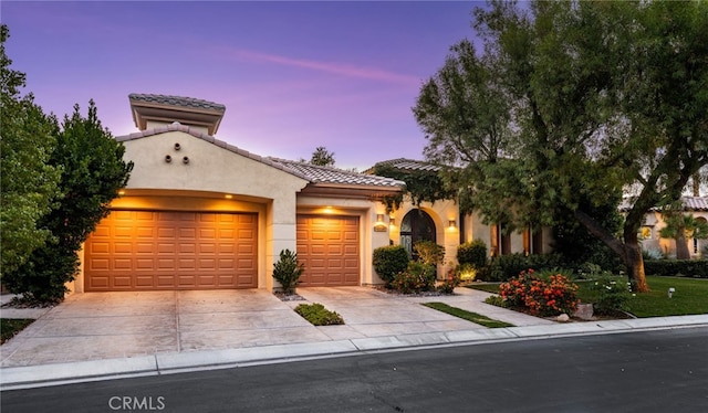 56102 Baltusrol Ln, Quinta, CA 92253 - mediterranean / spanish home featuring an attached garage, concrete driveway, stucco siding, and a tile roof