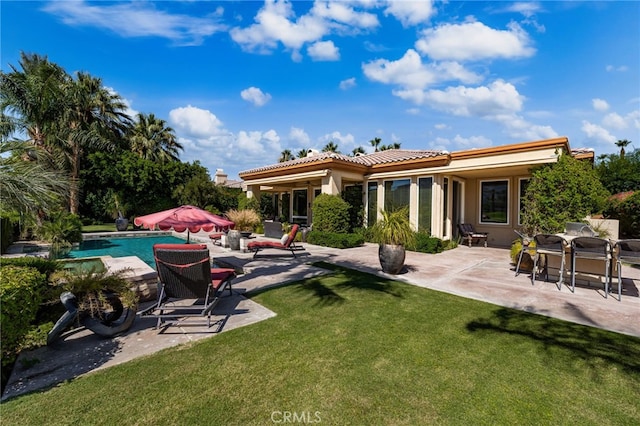 56102 Baltusrol Ln, Quinta, CA 92253 - back of house with stucco siding, a patio area, a lawn, and an outdoor pool
