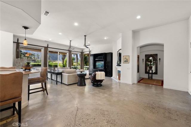 56102 Baltusrol Ln, Quinta, CA 92253 - living room featuring finished concrete flooring, recessed lighting, and arched walkways