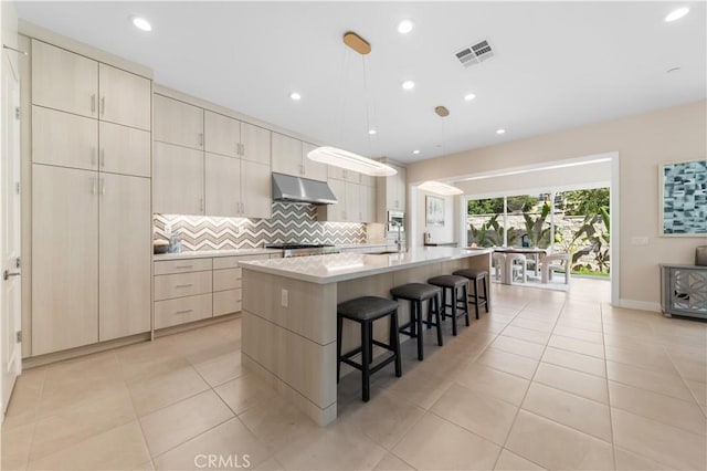 390 Riverbend, Lake Forest, CA 92630 - kitchen with under cabinet range hood, backsplash, a large island, light countertops, and a breakfast bar area